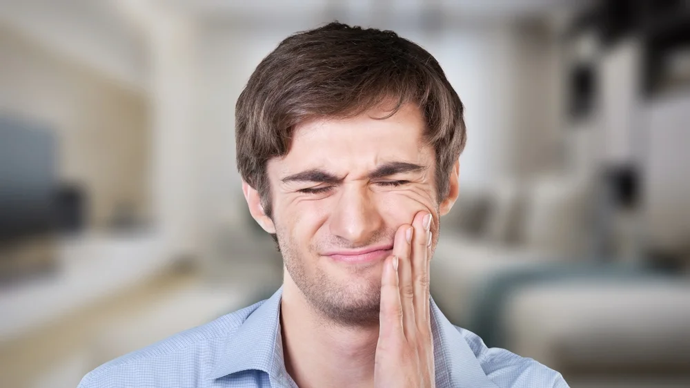 young man clenching his jaw tmj